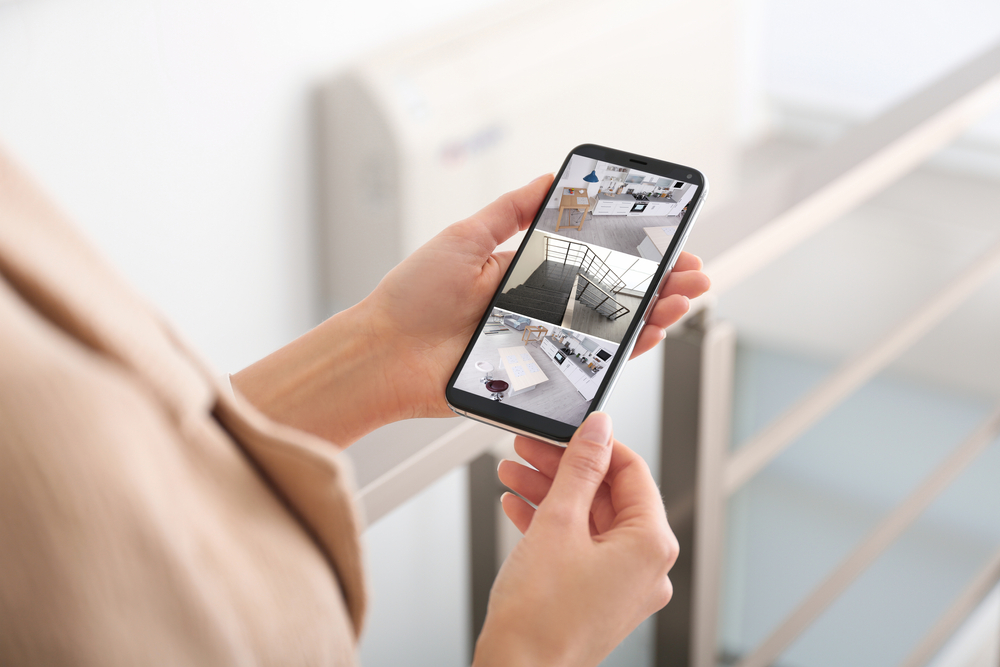 Woman,Monitoring,Modern,Cctv,Cameras,On,Smartphone,Indoors,,Closeup.,Home